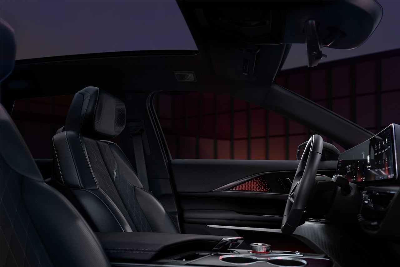 A Woman Activates the Dual Glass Power Sunroof of a 2025 Cadillac XT4 in the City