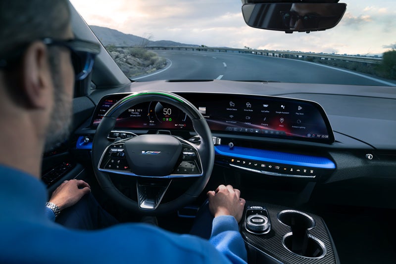 Front View of the 2026 OPTIQ-V Driving Through the Dusk Utilizing its Headlights | Sarant Cadillac in Farmingdale NY